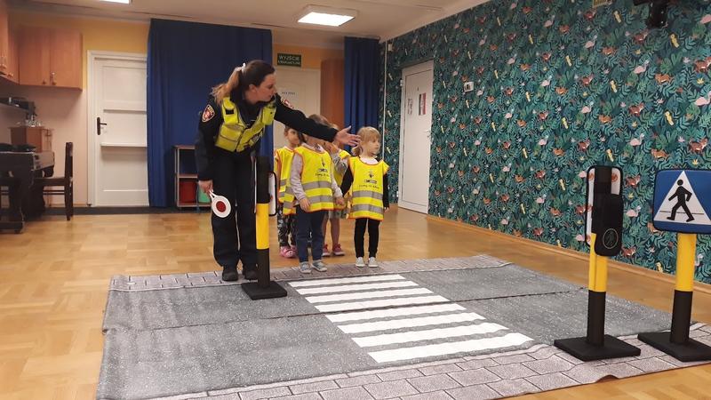 Nauka przedszkolaków zasad przechodzenie przez przejście dla pieszych przez strażniczkę Straży Miejskiej